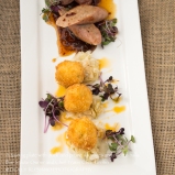 A tasting plate of duck and prune sausages and risotto balls